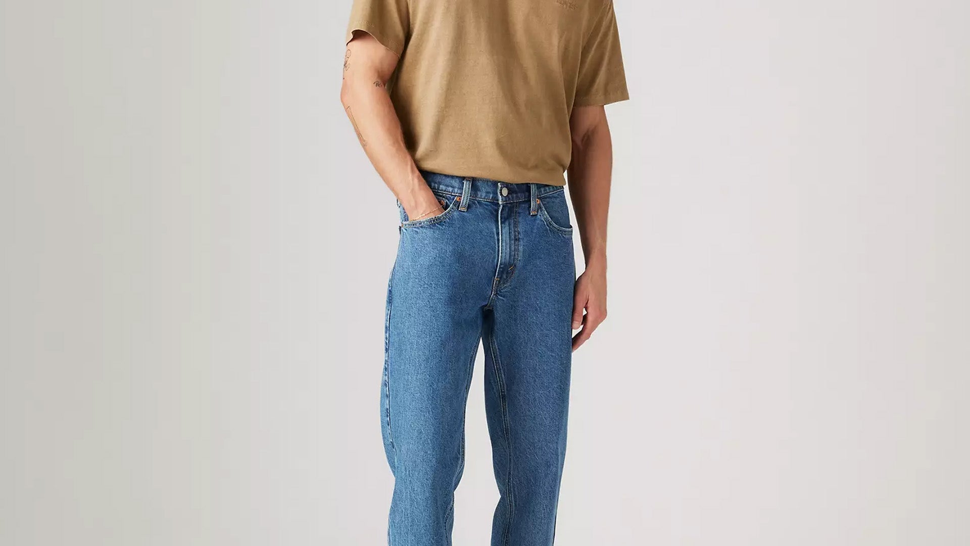 Man in jeans, accompanying a guide to testicular self-examination