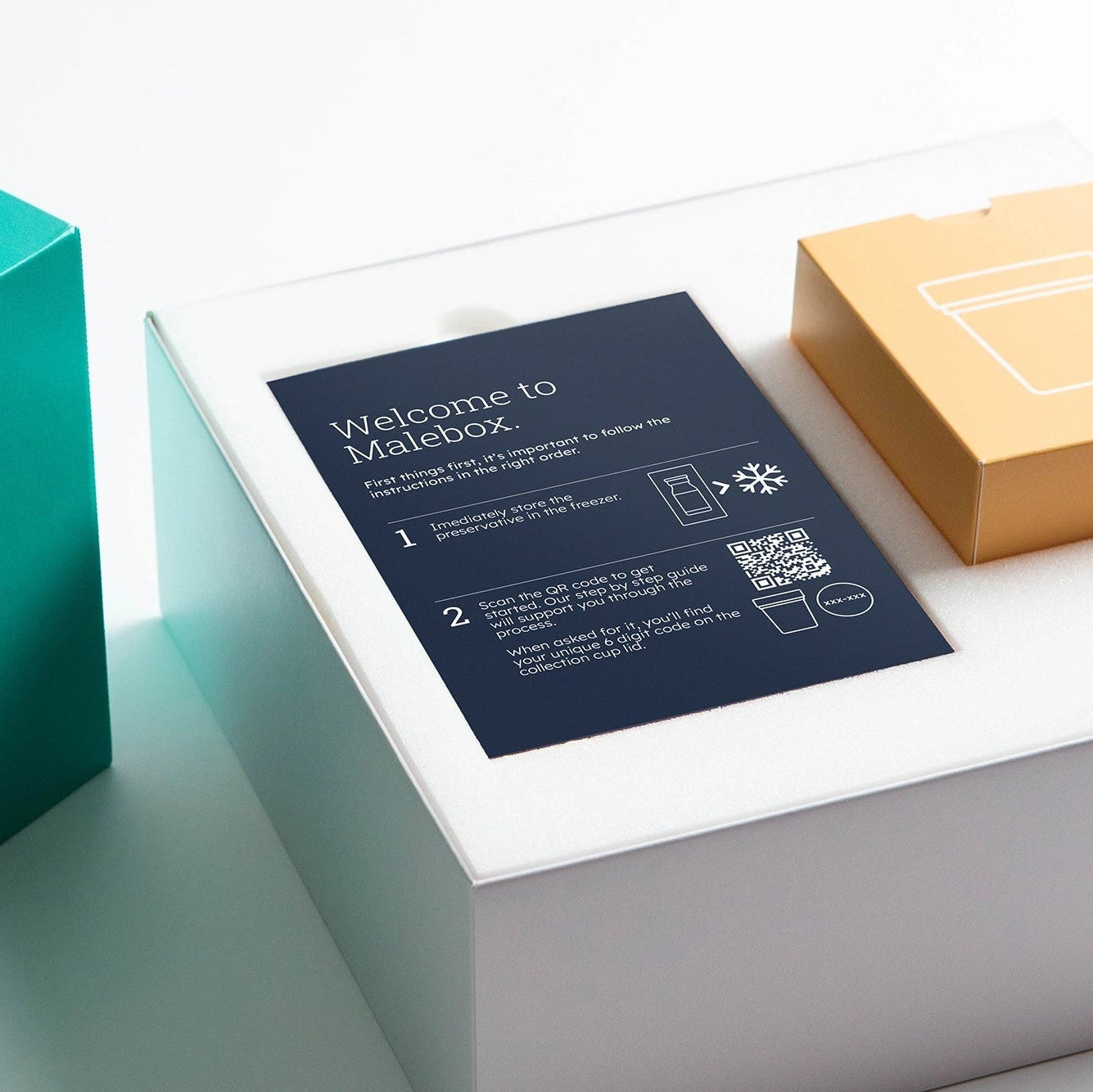 Teal box with a white lid featuring a product and a card on a light gray background